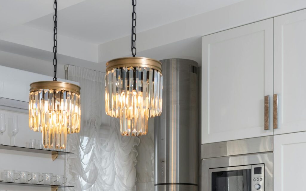 Bright modern kitchen interior with elegant lighting and stainless steel appliances.