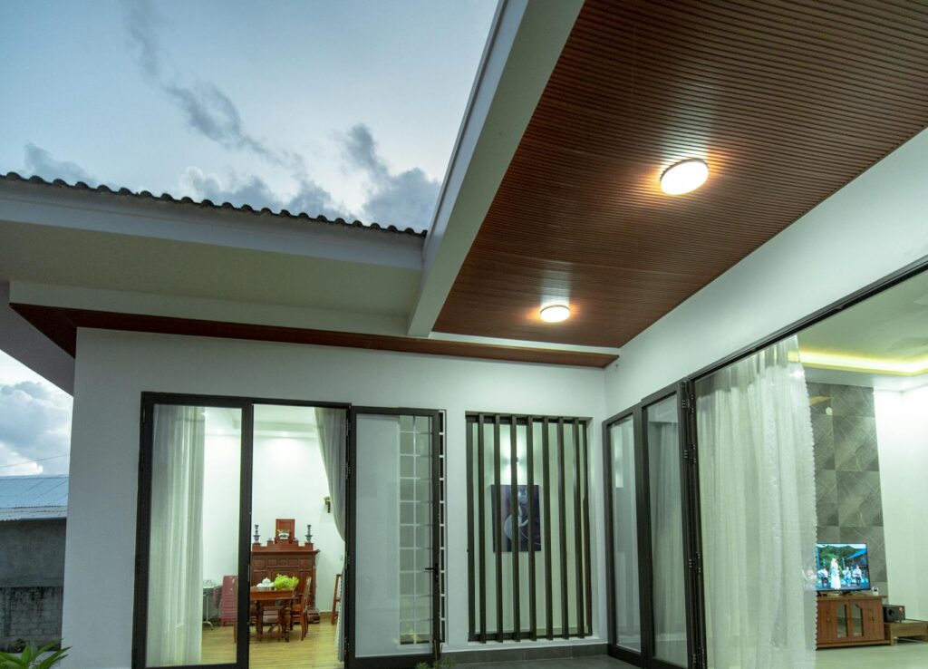 Contemporary house exterior featuring sliding doors and stylish lighting at dusk.